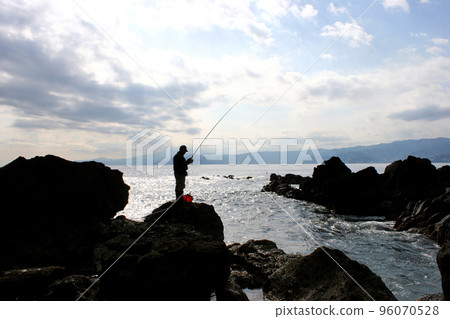 Standing on the tip of the shore and fishing for porgies Standing on the tip of the shore and fishing for porgies 96070528