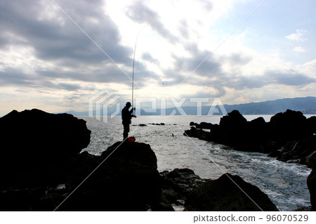 Standing on the tip of the shore and fishing for porgies Standing on the tip of the shore and fishing for porgies 96070529