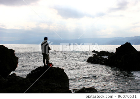 Standing on the tip of the shore and fishing for porgies Standing on the tip of the shore and fishing for porgies 96070531