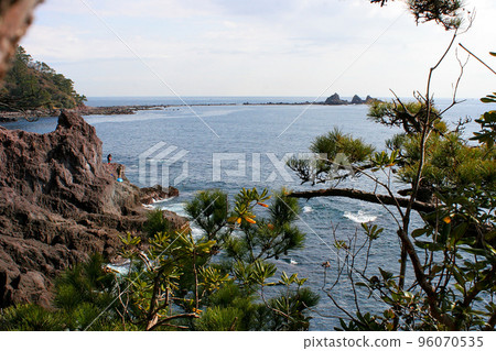 Standing on the tip of the shore and fishing for porgies 96070535