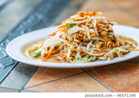 Papaya salad or Som Tum Thai, Thailand food spicy and sour papaya salad, side view, close-up image, natural warm light. 96071190