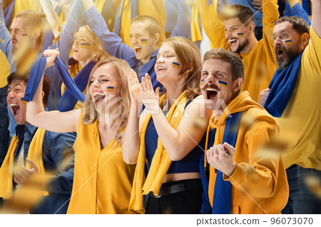 Group of young people, thrilled excited soccer football fans cheering for their sport team at stadium. Concept of emotions, global sports competitions, championship 96073070