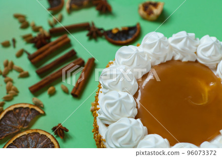 Caramel cake with nuts and caramel sauce glaze. whipped cream with cinnamon. rounded tart or pie 96073372