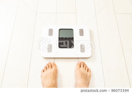 Men's feet on the weight scale Men's feet on the weight scale 96073394