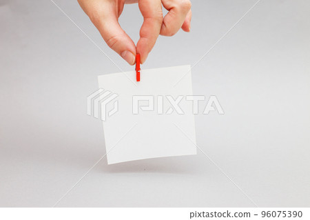 human hand holding sticker with empty mockup for your text hanging on the pin on gray background. human hand holding sticker with empty mockup for your text hanging on the pin on gray background. 96075390