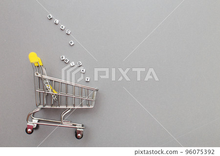 The metal shopping cart on a grey background. black friday sale concept The metal shopping cart on a grey background. black friday sale concept 96075392