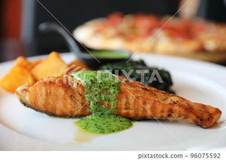 Salmon steak with pesto sauce Salmon steak with pesto sauce 96075592