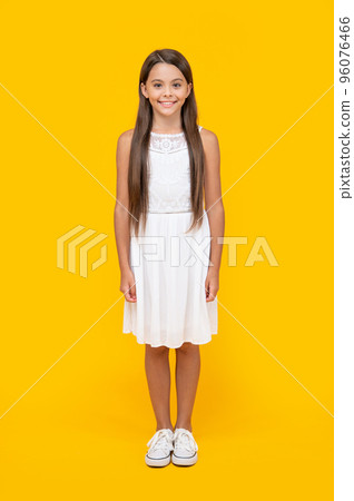 cute teen girl in white dress standing on yellow background cute teen girl in white dress standing on yellow background 96076466