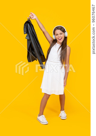 shouting teen kid listen music in headphones on yellow background 96076467