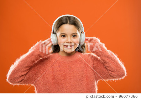 Using bluetooth wireless technology. Little child listening to music in bluetooth stereo earphones. Small girl wearing modern bluetooth headphones. Connecting bluetooth headset to her music player 96077366