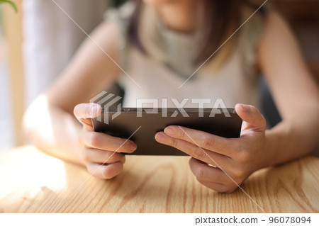 Woman hand using a smartphone for Stock exchange trading online in the coffee shop, business concept 96078094