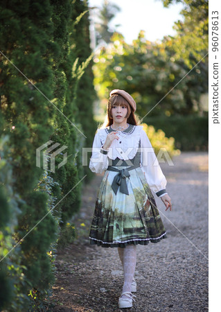 A beautiful woman in lolita dress in garden background Japanese street fashion portrait 96078613