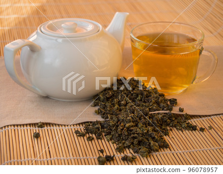 Teapot and Cup of herbal green tea on bamboo napkin 96078957