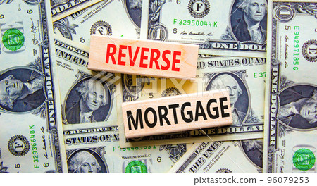 Reverse mortgage symbol. Concept words Reverse mortgage on wooden blocks. Beautiful background from dollar bills. Business and reverse mortgage concept. Copy space. 96079253