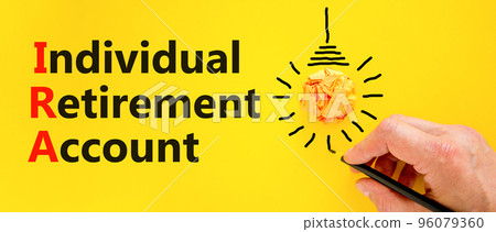 IRA individual retirement account symbol. Concept words IRA individual retirement account on a beautiful yellow background. Light bulb. Business IRA individual retirement account concept. Copy space IRA individual retirement account symbol. Concept words IRA individual retirement account on a beautiful yellow background. Light bulb. Business IRA individual retirement account concept. Copy space 96079360