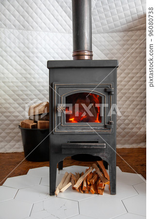 A vintage stove is heated with wood, heats a country house. 96080738