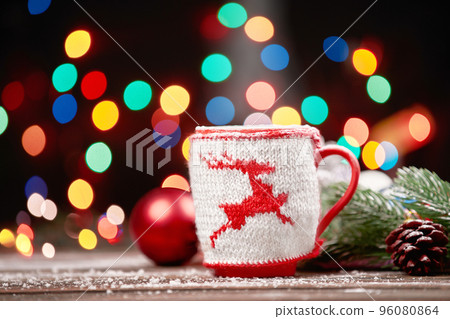 cup of coffee with a Christmas ornament on a festive background. 96080864