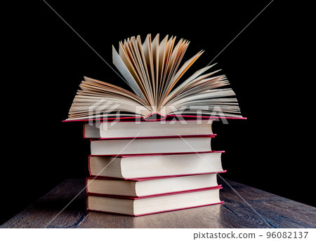 Stack of red-bound paper books on a wooden table. Stack of red-bound paper books on a wooden table. 96082137