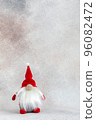 Crochet handmade gnome in red hat Christmas holiday card on light winter background 96082472