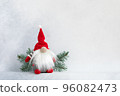 Christmas gnome in red cap with fir branch holiday invitation card on light winter background 96082473