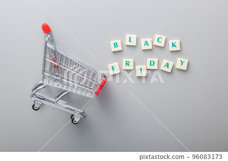 Black friday text and shopping cart on gray background. Top view. Black friday text and shopping cart on gray background. Top view. 96083173