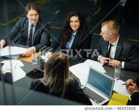 Group of business people having meeting in office, viewed from above. Partners sharing ideas and planning strategy. Concept of business Group of business people having meeting in office, viewed from above. Partners sharing ideas and planning strategy. Concept of business 96083808
