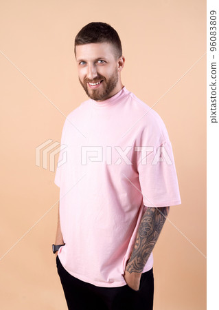 bearded hipster man with stylish haircut and tattoo in fashionable casual clothes pink t-shirt  96083809