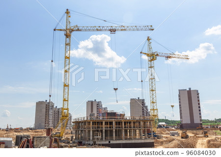 Cranes and building construction site against blue sky. 96084030