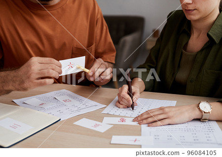 Male tutor of Chinese language pointing at paper card with hieroglyph Male tutor of Chinese language pointing at paper card with hieroglyph 96084105