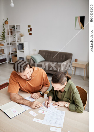 Above view of young tutor explaining new subject to student at home lesson 96084106