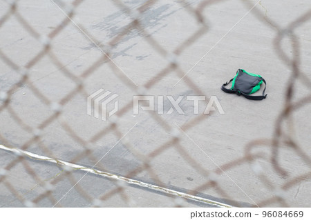 透過籃球場上的穿孔圍欄看到的背包 96084669