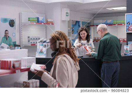 Senior man asking pharmacy worker for pharmaceutical vitamin during medical consultation in drugstore. Helpful druggist recommending supplements for healthy immune system to old customer 96084823