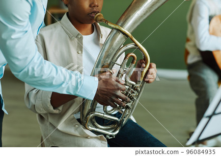 Close-up of hand of young African American music teacher helping schoolboy Close-up of hand of young African American music teacher helping schoolboy 96084935