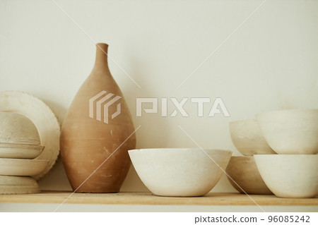 Raw handmade ceramics on shelf in pottery studio 96085242