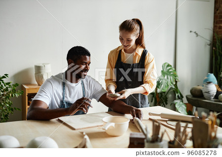 Couple enjoying art class in pottery studio together Couple enjoying art class in pottery studio together 96085278