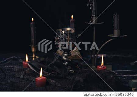 Witchcraft composition with candles, magic book and pentagram symbol. Altar for satanic rituals. Black magic and occult objects. Witchcraft composition with candles, magic book and pentagram symbol. Altar for satanic rituals. Black magic and occult objects. 96085346