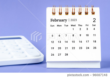 The February 2023 Monthly desk calendar for 2023 year with calculator on purple background. 96087148