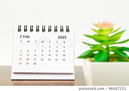 The February 2023 Monthly desk calendar for 2023 year with small plant on wooden table. The February 2023 Monthly desk calendar for 2023 year with small plant on wooden table. 96087233