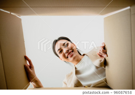 Surprised young asian woman unpacking 96087658