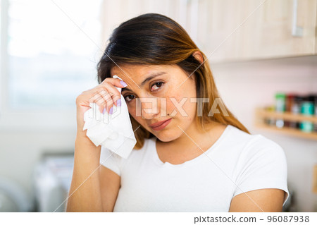 Unhappy mexican housewoman crying during cooking at home Unhappy mexican housewoman crying during cooking at home 96087938