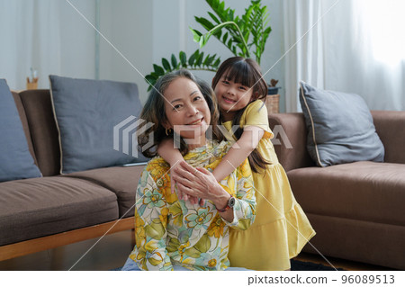 Asian portrait, grandma and granddaughter doing leisure activities and hugging to show their love and care for each other. 96089513