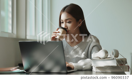 Happy young Asian student girl using laptop in university campus or at virtual office. College female student learning remotely. 96090337