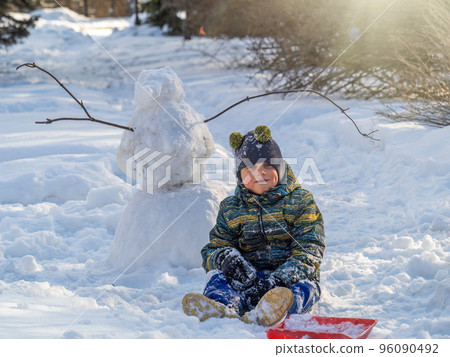 Happy baby boy playing in the snow Happy baby boy playing in the snow 96090492