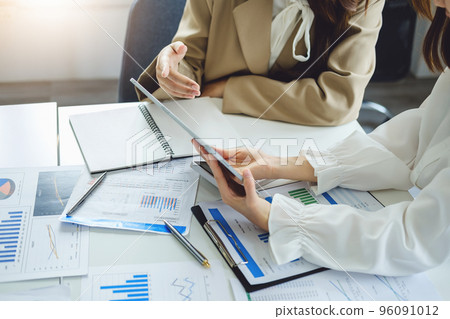Negotiation, Analysis, Discussion, Asian women economist and marketer using tablet computer to plan investments and financial to prevent risks and losses for the company. 96091012