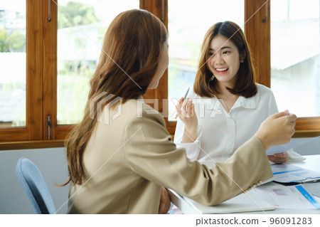 Negotiation, Analysis, Discussion, Portrait of an Asian woman economist and marketer pointing to a financial data sheet to plan investments to prevent risks and losses for the company. 96091283