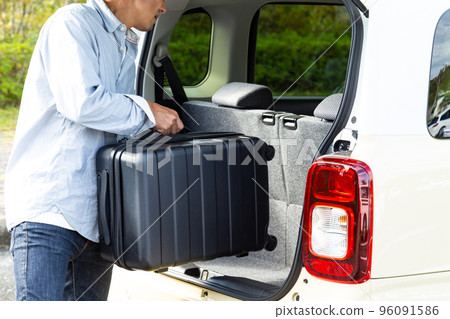 man carrying a suitcase 96091586