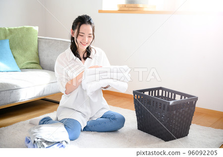 A woman folding laundry such as towels Smile 96092205