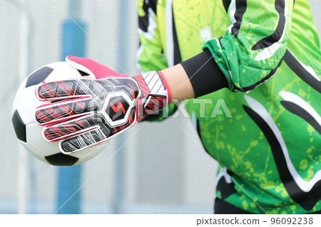 Goalkeeper man catching a soccer ball 96092238