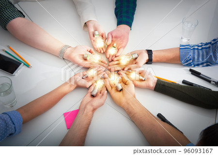 Teamwork and brainstorming concept with businessmen that share an idea with a lamp. Concept of startup Teamwork and brainstorming concept with businessmen that share an idea with a lamp. Concept of startup 96093167