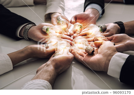 Teamwork and brainstorming concept with businessmen that share an idea with a lamp. Concept of startup Teamwork and brainstorming concept with businessmen that share an idea with a lamp. Concept of startup 96093170